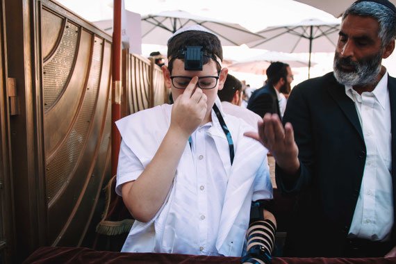 חתן בר מצווה מתפלל בכותל